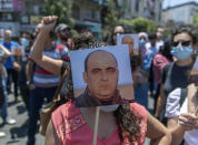 Angry demonstrators carry pictures of Nizar Banat, an outspoken critic of the Palestinian Authority, and chant anti-PA slogans during a rally protesting his death, in the West Bank city of Ramallah, Thursday, June 24, 2021. Banat who was a candidate in parliamentary elections called off earlier this year died after Palestinian security forces arrested him and beat him with batons on Thursday, his family said. (AP Photo/Nasser Nasser)