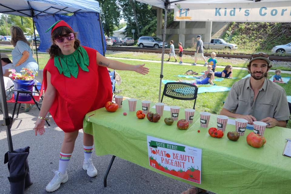 Laura Guinnessey, left, and Paul Friedheim, right, take votes for the Tomato Beauty Pageant at the Hendersonville Farmers Market Tomato Day in 2021.