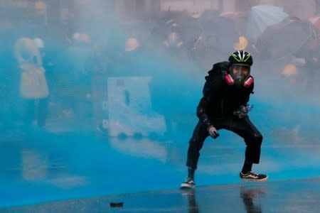 An anti-government protester is sprayed with water cannon by the police during a demonstration near Central Government Complex in Hong Kong