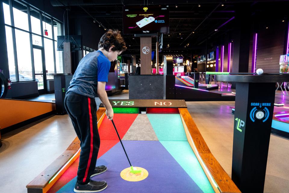 Odin Street, 8, putts on a miniature golf course at Putts and Pins in West Des Moines.