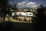FILE- In this March 24, 2008 file photo, Bhutanese people queue up to cast their votes outside a polling station, in Thimphu, Bhutan.Bhutan’s COVID-19 vaccination drive was fast from the start. As other countries rolled out their vaccination campaigns over months, Bhutan is nearly done just 16 days after it started. The tiny Himalayan kingdom has vaccinated nearly 93% of its adults. (AP Photo/Manish Swarup, File)