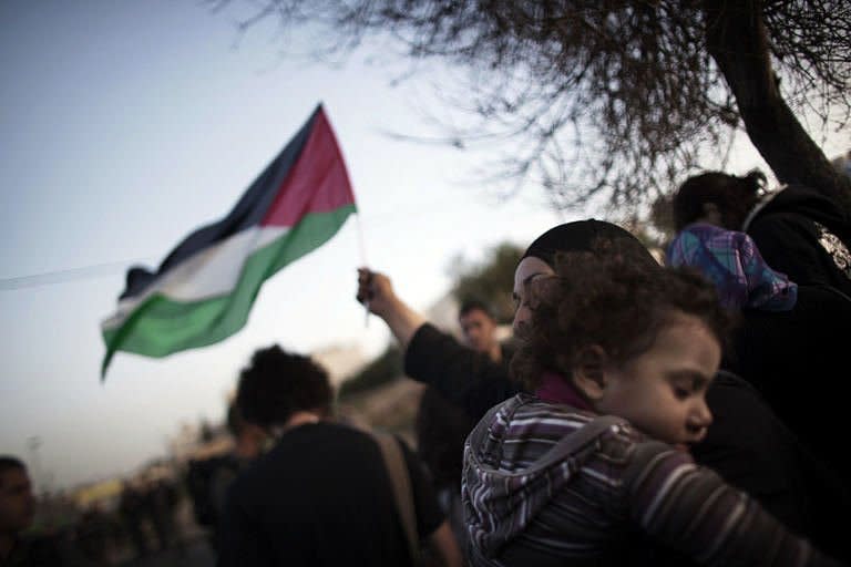 A Palestinian woman waves her national flag, while holding her sleeping baby, in 2010 during a demonstration in the mostly Arab Jerusalem neighborhood of Sheikh Jarrah against Israeli settlements and occupation. The Palestinians are to present their bid for United Nations membership on September 20, Palestinian foreign minister Riyad al-Malki told AFP on Saturday