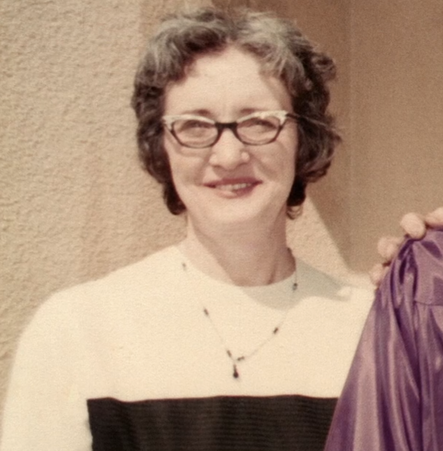 closeup of Mary smiling with very short hair and small glasses