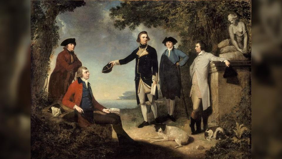 A painting showing five men, two dogs, and a statue of a woman standing in a clearing near the ocean shore. The center man, James Cook, is holding his hat out.