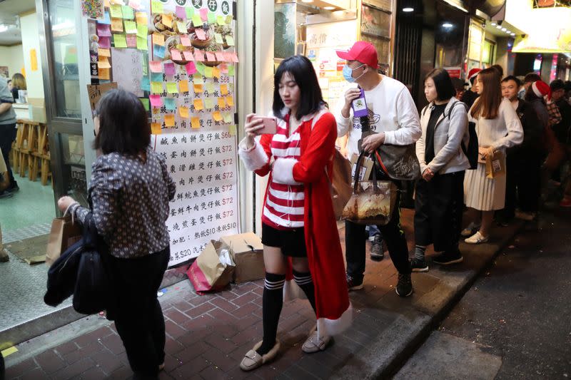 Protesters queue for a free Christmas dinner offered by a local restaurant in Hong Kong