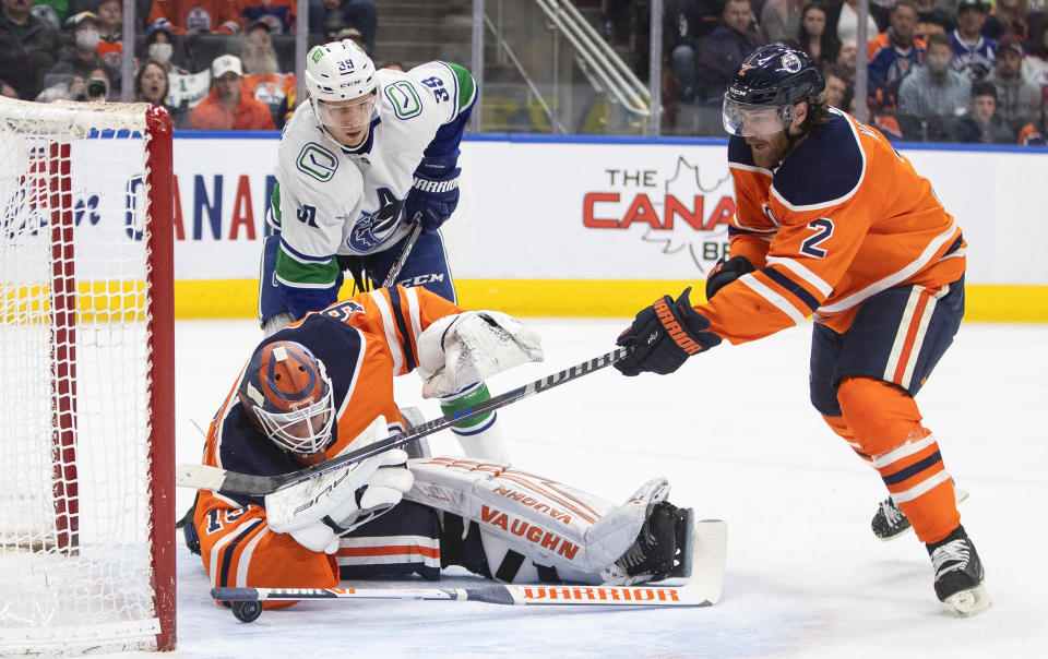 Vancouver Canucks' Alex Chiasson (39) looks for a rebound as Edmonton Oilers goalie Mikko Koskinen (19) makes a save and Duncan Keith (2) defends during the first period of an NHL hockey game Friday, April 29, 2022, in Edmonton, Alberta. (Jason Franson/The Canadian Press via AP)