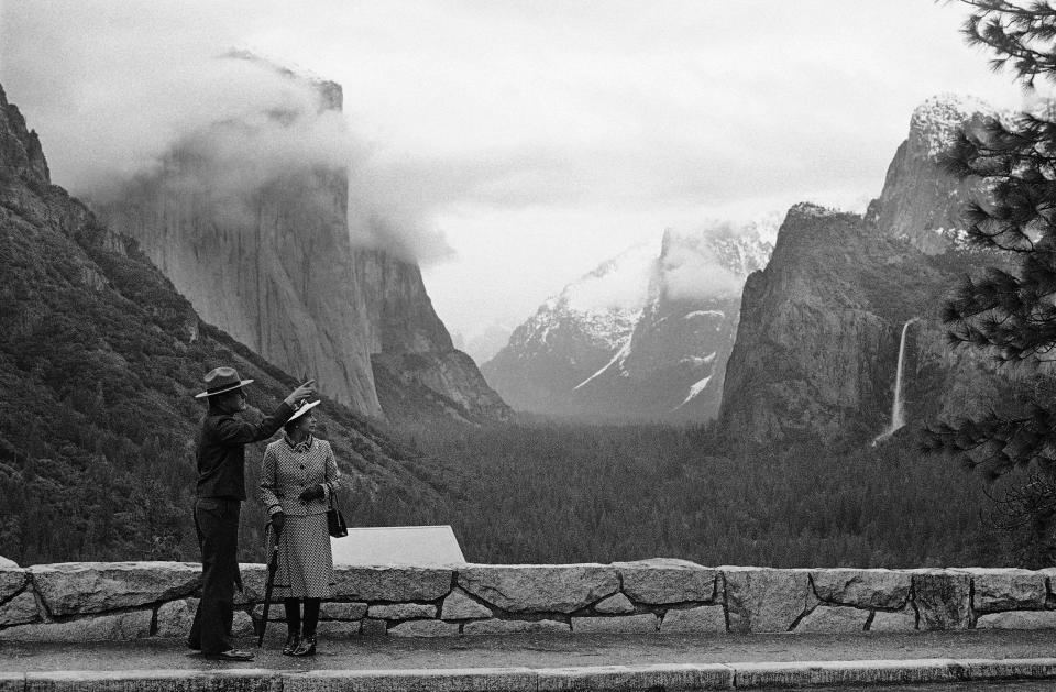 FILE - In this March 5, 1983 file photo taken by Walt Zeboski, park superintendent Bob Binnewies points out highlights from Inspiration Point to Queen Elizabeth II during her visit to Yosemite National Park, in California. Walt Zeboski, who chronicled Ronald Reagan's 1980 presidential campaign and a succession of California governors as a photographer for The Associated Press, has died. He was 83. (AP Photo/Walt Zeboski, File)