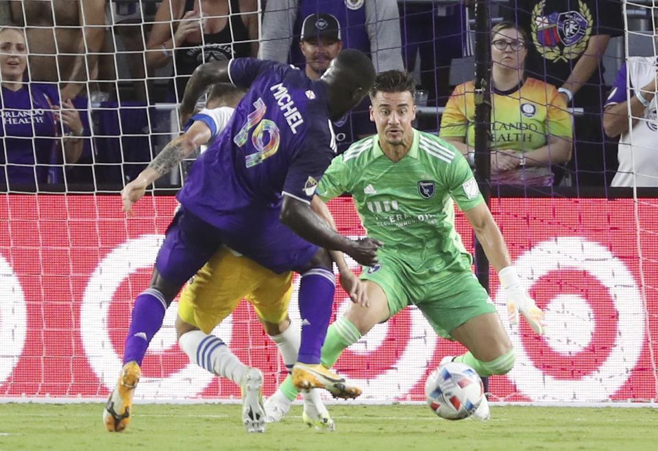 Orlando player Benji Michel, left, scores a goal past San Jose goalkeeper J.T. Marcinkowski, right, during a MSL soccer match in Orlando, Fla., on Tuesday, June 22, 2021. (Stephen M. Dowell /Orlando Sentinel via AP)