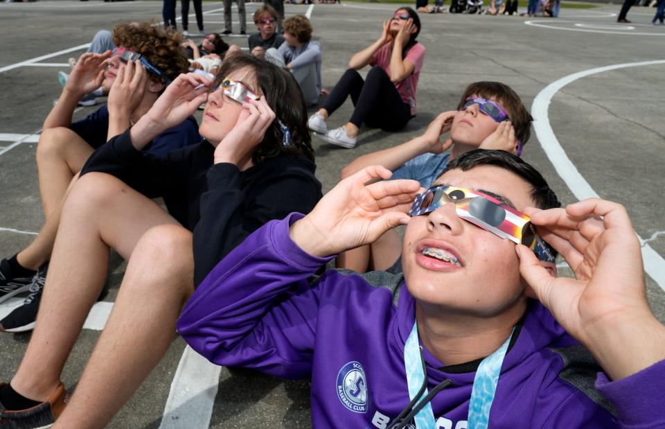 Eighth-grader Antonio Fuster, right, along with his classmates at Creekside Middle School in Port Orange, watch the 63% solar eclipse. Students with permission slips from their parents were allowed to view the eclipse as part of an in-school field trip.