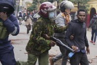 Kenya anti riot police arrest a man during a protest in Nairobi, Kenya Thursday, June 27, 2024. Thousands of protesters stormed and burned a section of Kenya's parliament Tuesday to protest tax proposals. Police responded with gunfire and several protesters were killed. (AP Photo/Brian Inganga)