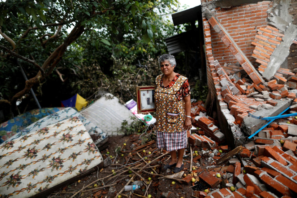 <p>Maria Guzman, 70, a housewife, poses for a portrait on the rubble of her house after an earthquake in San Jose Platanar, at the epicentre zone, Mexico, September 28, 2017. The house was badly damaged, but with the help of her family Guzman rescued some furniture. She lives in a shelter and hopes her home will be rebuilt. “The most valuable thing that I recovered was the photo of my wedding day,” Guzman said. (Photo: Edgard Garrido/Reuters) </p>