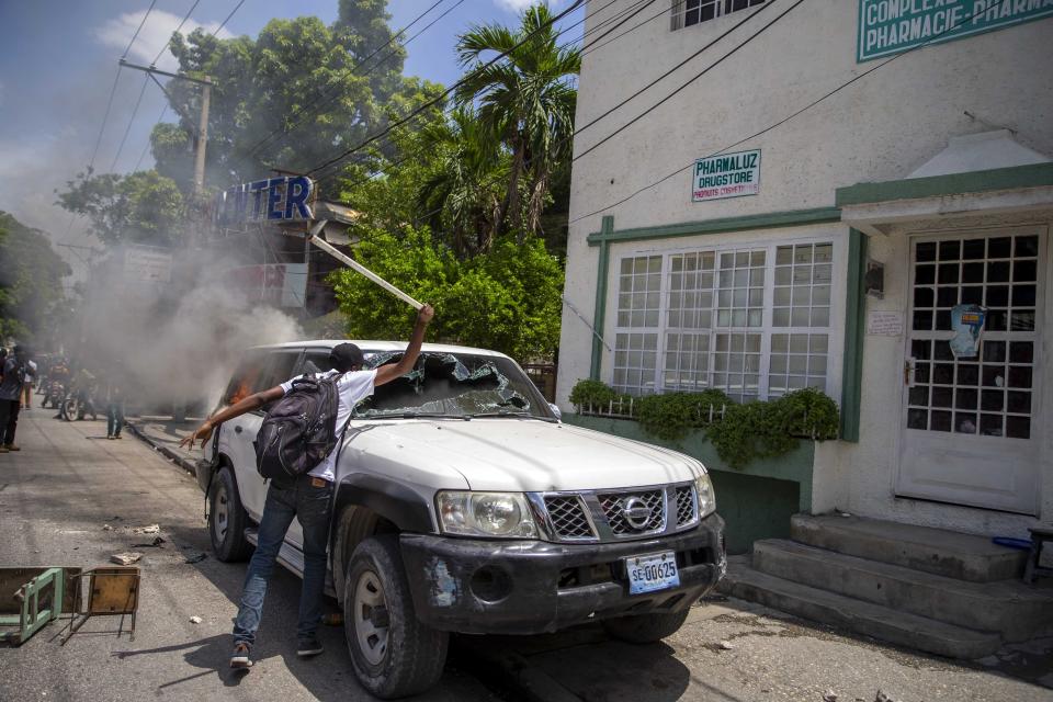 FILE - In this Sept. 1, 2020 file photo, a demonstrator shatters the windshield of a government vehicle during a protest to demand justice for the murder of Bar Association President Monferrier Dorval, in Port-au-Prince, Haiti. The capital city has seen an increase in gang violence and kidnappings while the government has proven to be incapable of controlling it. (AP Photo/Dieu Nalio Chery, File)