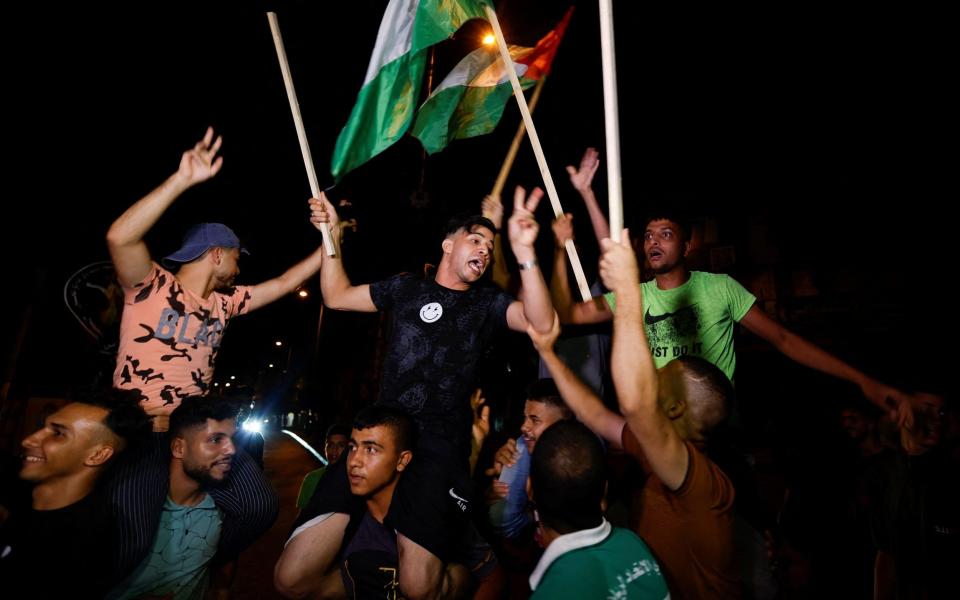 Palestinians celebrate on a Gaza City street after a ceasefire was announced - REUTERS/Ibraheem Abu Mustafa