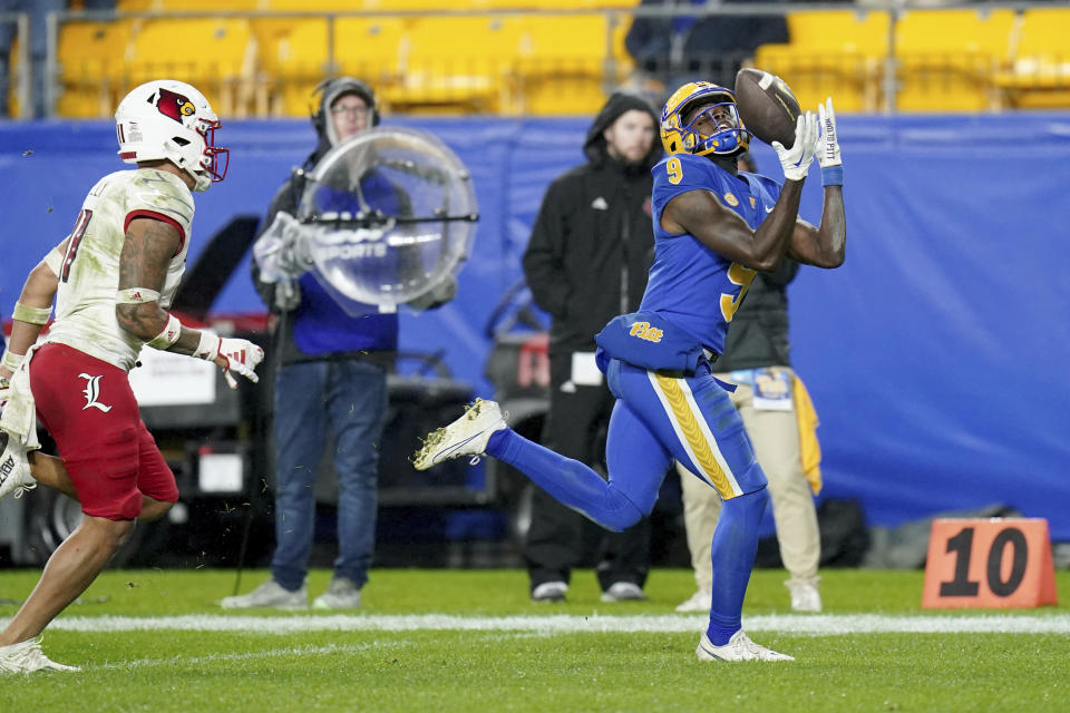 Pittsburgh wide receiver Konata Mumpfield (9) pulls in a pass for a touchdown in front of Louisville defensive back Cam'Ron Kelly (11) during the second half of an NCAA college football game in Pittsburgh, Saturday, Oct. 14, 2023. (AP Photo/Matt Freed)