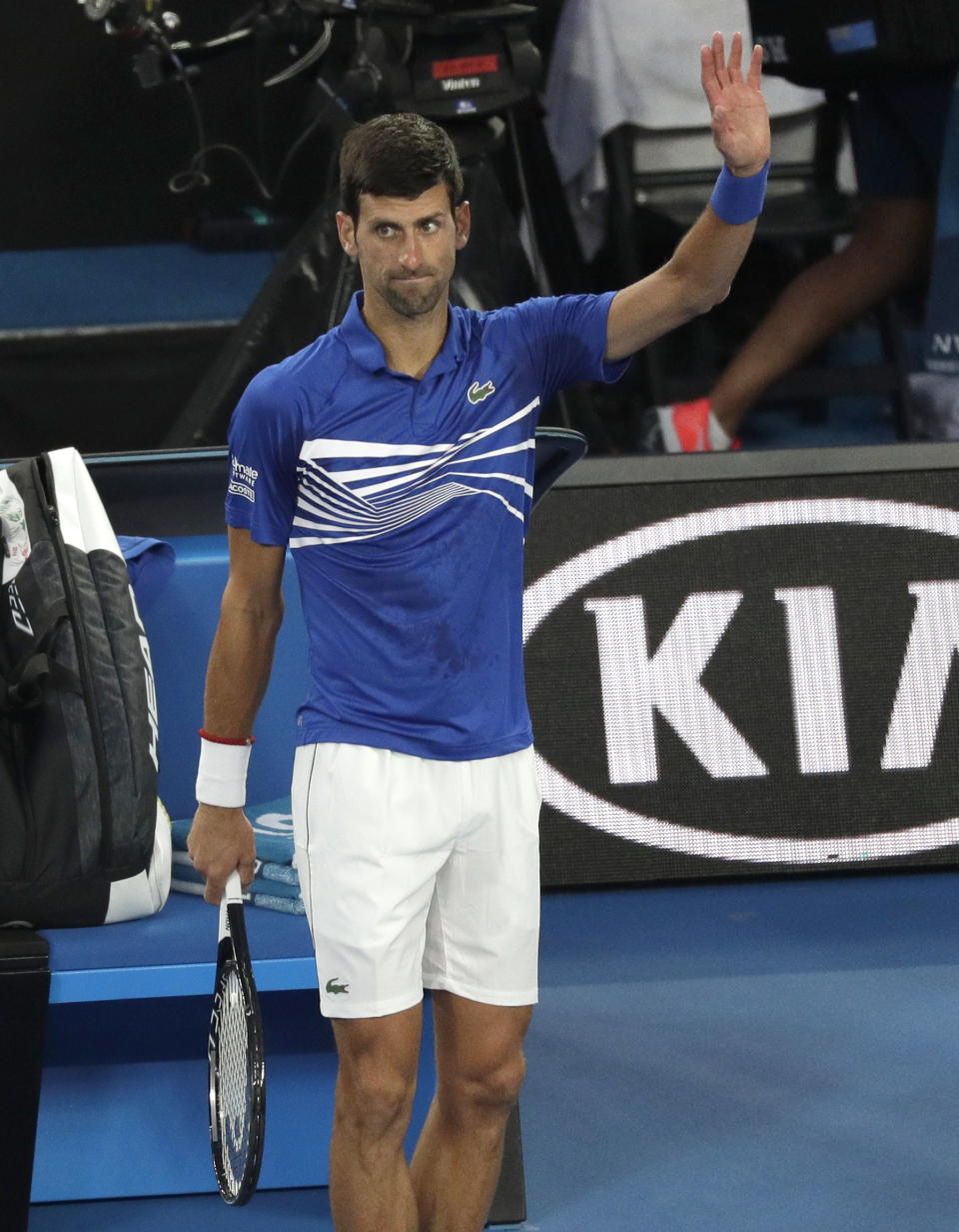 Serbia's Novak Djokovic waves to the crowd after Japan's Kei Nishikori retired injured from their quarterfinal at the Australian Open tennis championships in Melbourne, Australia, Wednesday, Jan. 23, 2019.(AP Photo/Kin Cheung)