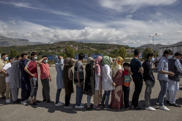 Refugiados afganos en fila para una distribución de ropa en un campamento dirigido por la Cruz Roja Italiana en Avezzano, Italia, el 2 de septiembre de 2021. Los miembros del equipo de Herat dejaron atrás las vidas que habían construido en Afganistán con la esperanza de poder construir un futuro donde puedan jugar y prosperar.