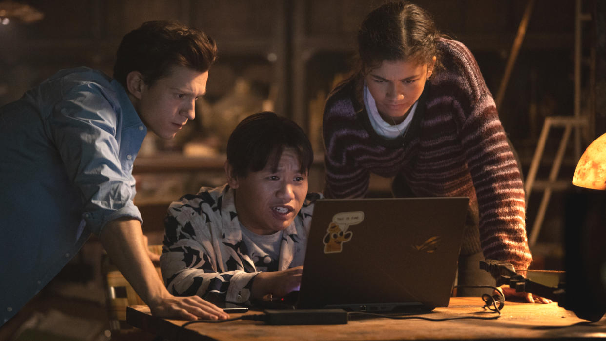  A confused Jacob Batalon sits at a computer with Tom Holland and Zendaya beside him in Spider-Man: No Way Home. 