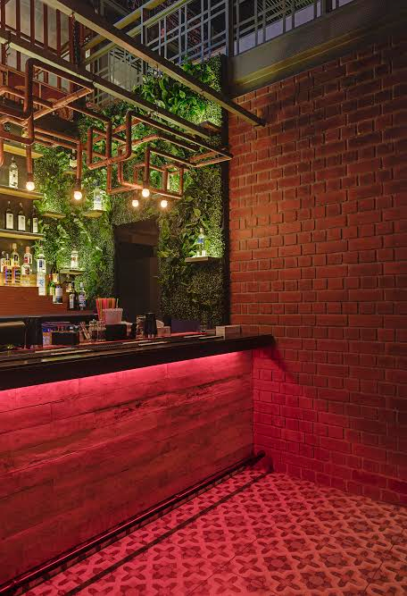 The bar facade on the ground floor is clad with distressed wooden planks rendering it a grungy yet warm appeal. The open brick face wall just by its side complements the bar.