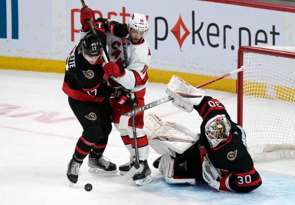 Ottawa Senators goaltender Matt Murray makes a save as center Adam Gaudette battles with Carolina Hurricanes center Vincent Trocheck during the first period of an NHL hockey game, Thursday, Jan. 27, 2022 in Ottawa, Ontario. (Adrian Wyld/The Canadian Press via AP)