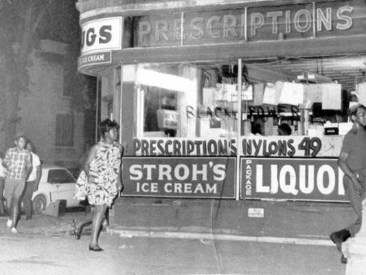 People rush past a drug store that is being looted on Detroit's West Side during the civil unrest of 1967. "Black Power" has been written on one of the windows. UPI Telephoto