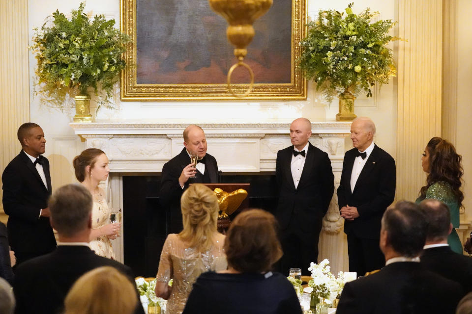 Colorado Gov. Jared Polis, vice chair of the National Governors Association, from left, speaks to members of the National Governors Association and their spouses as Utah Gov. Spencer Cox and President Joe Biden look on before a dinner in the State Dining Room of the White House in Washington, Saturday, Feb. 24, 2024. (AP Photo/Stephanie Scarbrough)