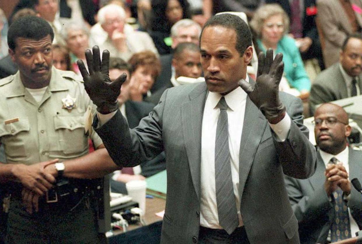 O.J. Simpson shows the jury a pair of gloves, similar to those found near the crime scene, during his trial in Los Angeles in 1995. <a href="https://www.gettyimages.com/detail/news-photo/simpson-shows-the-jury-a-new-pair-of-aris-extra-large-news-photo/51988465?adppopup=true" rel="nofollow noopener" target="_blank" data-ylk="slk:POO/AFP via Getty Images;elm:context_link;itc:0;sec:content-canvas" class="link ">POO/AFP via Getty Images</a>