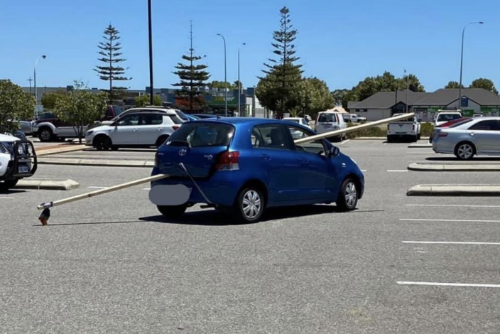 Toyota Yaris pictured with a large pole sticking out of its boot and window.