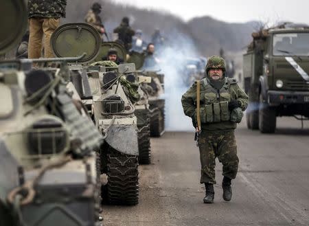 Members of the Ukrainian armed forces and armoured personnel carriers are seen preparing to move as they pull back from Debaltseve region, near Artemivsk February 26, 2015. REUTERS/Gleb Garanich