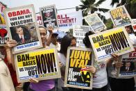 Protesters hold placards during a protest against the upcoming visit of U.S. President Barack Obama next week, in front of the U.S. embassy in Manila April 23, 2014.