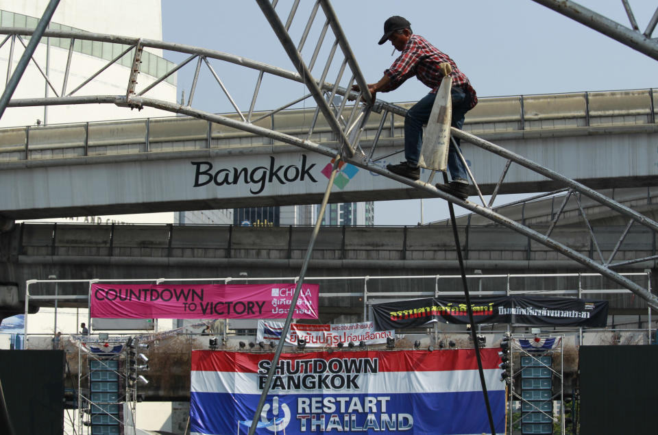 A construction worker disassembles tent frames at the main protest stage before it is removed from a popular intersection in Bangkok, Thailand, Sunday, March 2, 2014. The anti-government protesters withdrew from several stages erected at key intersections around Bangkok. Starting Monday, they will consolidate at Lumpini Park, a central venue that has become a traditional protest site. (AP Photo/Wally Santana)