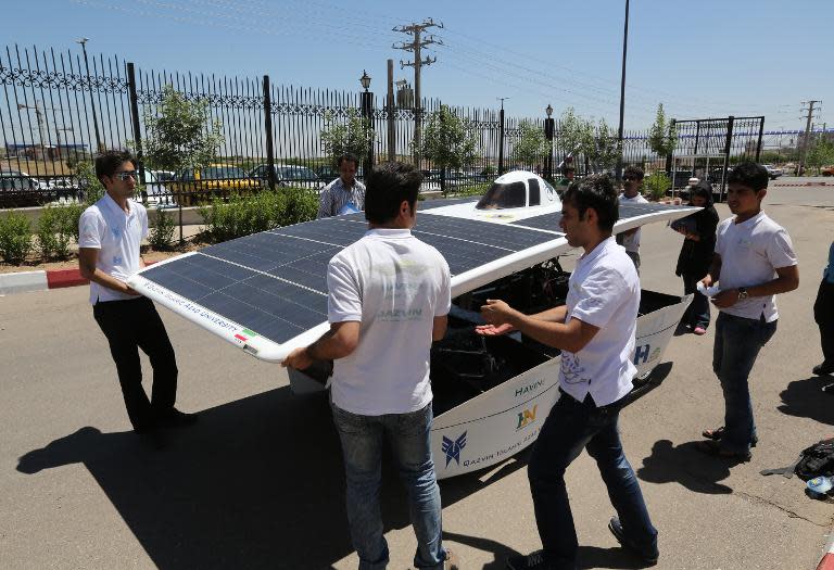 Iranian students from Qazvin Azad Islamic University assemble the solar-powered Havin-2 vehicle for a test drive in Qazvin on June 2, 2014