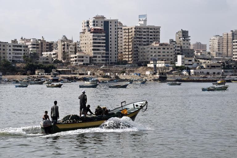 Fishermen ride a small boat into the harbour on August 18, 2014 in Gaza City