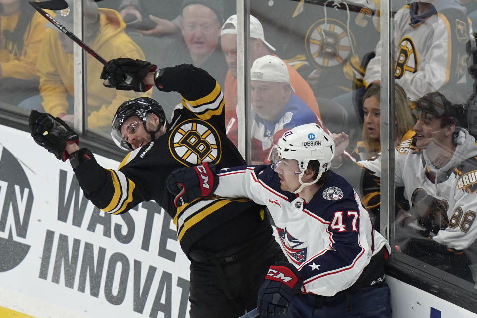 Boston Bruins center David Krejci, left, and Columbus Blue Jackets defenseman Marcus Bjork, right, slam into the boards after colliding in the first period of an NHL hockey game, Thursday, March 30, 2023, in Boston. (AP Photo/Steven Senne)