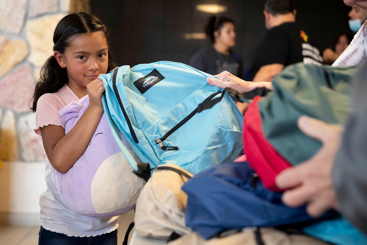 Children pick a free backpack filled with school supplies during the Back 2 School Backpack Giveaway at DACC East Mesa on Saturday, July 16, 2022.