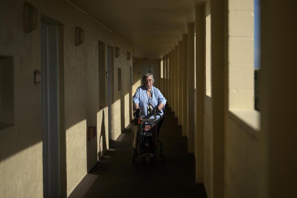 Joyce Loazia walks outside her apartment in a senior community in Coral Springs, Fla., Tuesday, Dec. 5, 2023. Loazia is among the first in the country to receive the robot ElliQ, whose creators, Intuition Robotics, and senior assistance officials say is the only device using artificial intelligence specifically designed to lessen the loneliness and isolation experienced by many older Americans. (AP Photo/Rebecca Blackwell)