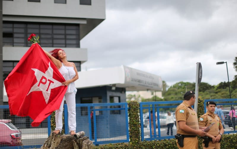 Supporter of Brazil's former president Luiz Inacio Lula da Silva waves a Workers Party (PT) flag, outside the Federal Police headquarters where Lula is serving a prison sentence, in Curitiba