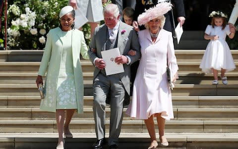 Arm in arm: Doria Ragland, mother of the bride, Prince Charles, Prince of Wales and Camilla, Duchess of Cornwall  - Credit: JANE BARLOW/AFP