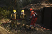 Firefighters operate during a wildfire near Lampiri village, west of Patras, Greece, Saturday, Jul. 31, 2021. The fire, which started high up on a mountain slope, has moved dangerously close to seaside towns and the Fire Service has send a boat to help in a possible evacuation of people. (AP Photo/Andreas Alexopoulos)