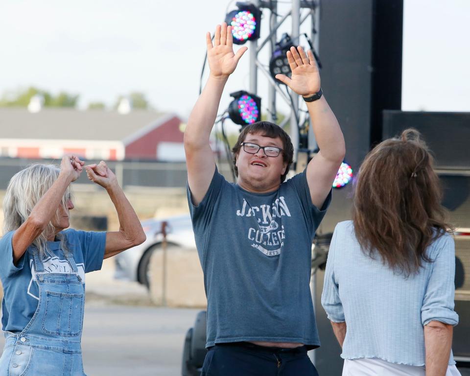 Austin Espinoza, center, busts a move alongside Tommie Vanbelt, left, and Pam Dasler while at the Lenawee County Fair's Thursday night grandstand event, “Bodacious Moves and Big Hair at the Fair: Lenawee’s Premier ’80s Dance Party.”