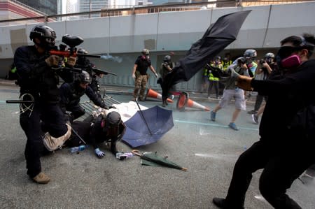A riot police officer fires pepper-spray projectile toward anti-government protesters demonstrating near the Legislative Council building in Hong Kong