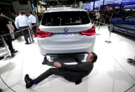 FILE PHOTO: A man checks the BMW iX3 electric concept car during a media preview at the Auto China 2018 motor show in Beijing