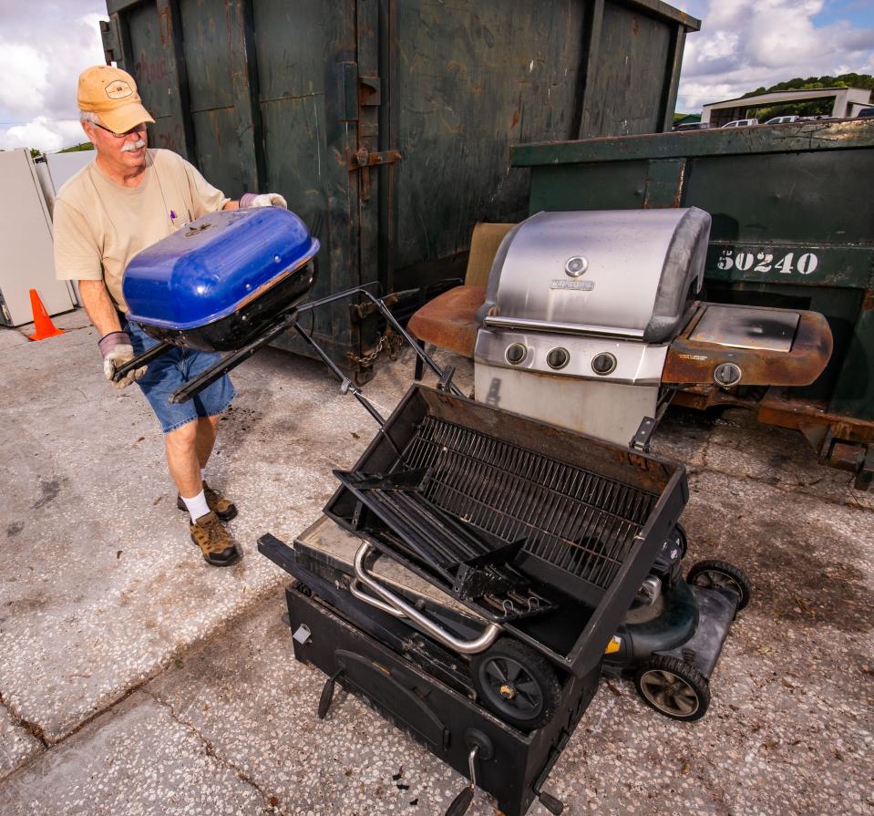 Danton Jones dumps an old charcoal grill in the metal recycling area as he and other people were dropping off household garbage and recyclables at the Baseline Recycling Center Friday morning, May 13.
