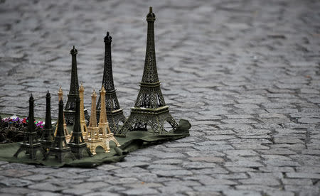 FILE PHOTO: Eiffel Tower souvenirs displayed by a street vendor are seen on the pavement next to the Sacre Coeur (Sacred Heart) basilica in Paris, France, July 31, 2017. REUTERS/Christian Hartmann/File Photo