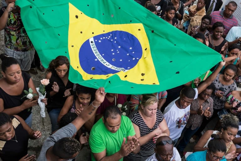 Relatives and friends carry a Brazilian flag with 50 holes as they mourn Wilton Esteves Domingos Junior, 20, killed with four other friends last Satuday by policemen who shot 50 times at their car, in Rio de Janeiro, on November 30, 2015