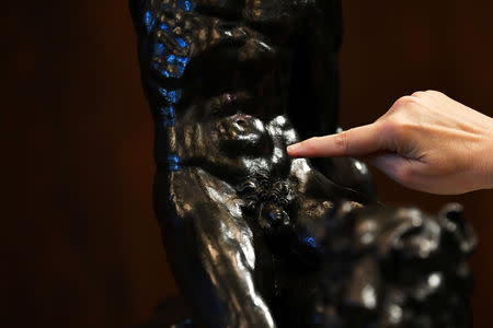 An art expert shows a detail of 'Rothschild Bronzes', confirmed as the only surviving bronze sculpture by Michelangelo, during an event at The Royal Academy of Arts (RA) in London, Britain, November 14, 2018. REUTERS/Dylan Martinez