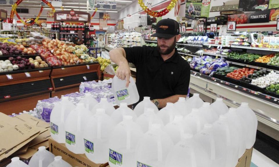Chris Creel, manager of Piggly Wiggly, stocks pallets of bottled water as grocery customers prepare for the arrival of storm weather with Hurricane Dorian in New Bern, North Carolina.