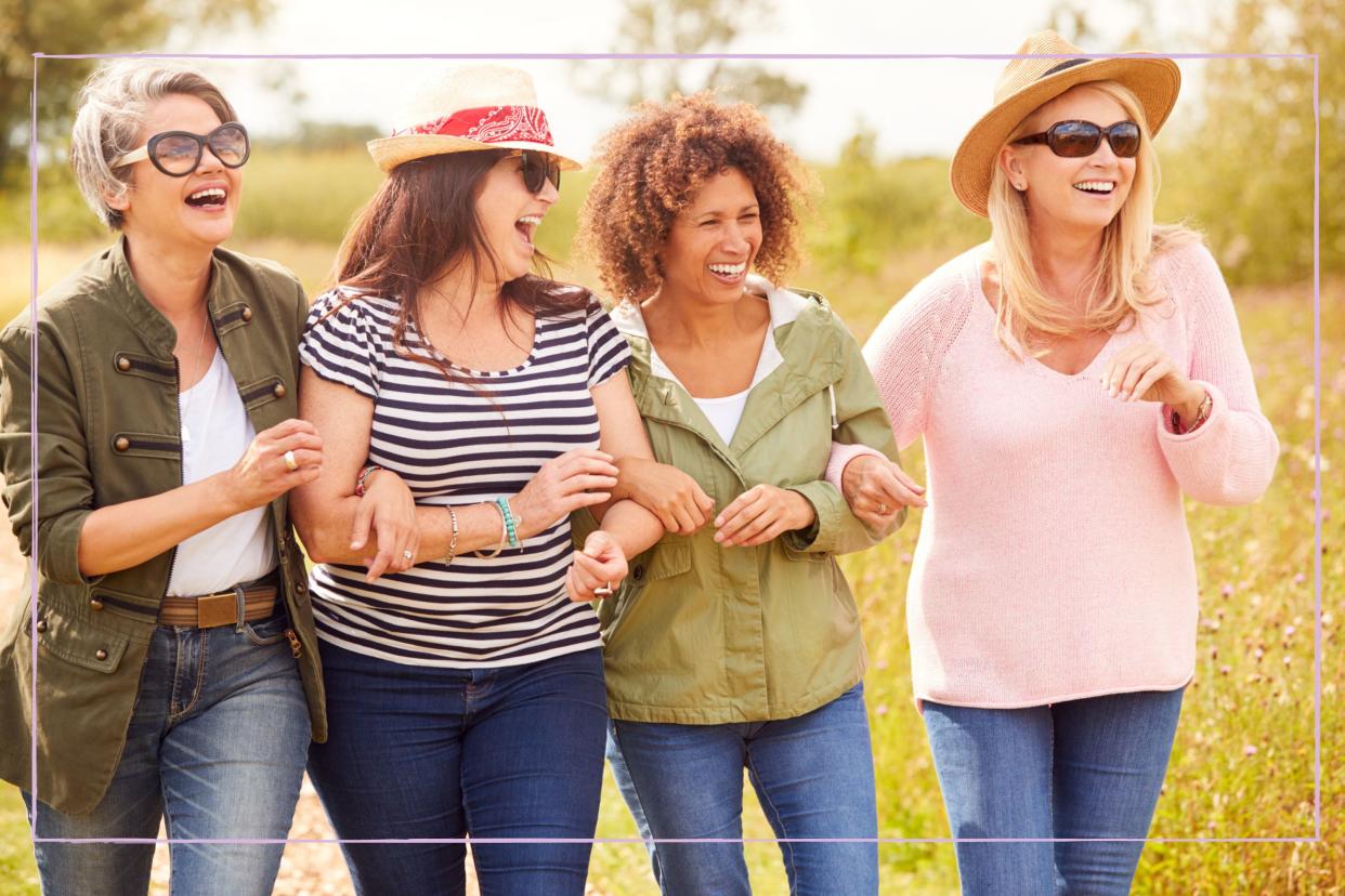  Group of female friends linked arms and laughing. 