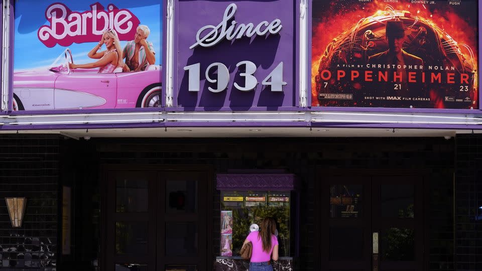 A patron buys a movie ticket underneath a marquee featuring the films "Barbie" and "Oppenheimer" at the Los Feliz Theatre, Friday, July 28, 2023, in Los Angeles. - Chris Pizzello/AP