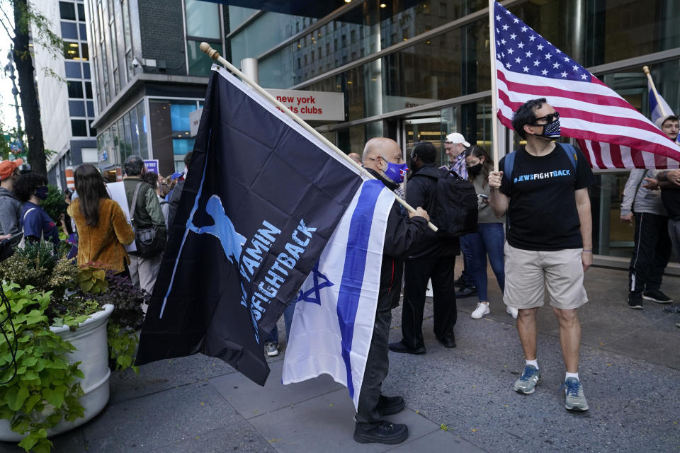 A man holds a Yad Yamin #Fightback flag along with an Israeli flag as he stands next to another man with an American flag as they joined protesters outside the offices of New York Gov. Andrew Cuomo, Thursday, Oct. 15, 2020, in New York. Three Rockland County Jewish congregations filed a lawsuit Wednesday accusing Gov. Andrew Cuomo of engaging in a streak of anti-Semitic discrimination with a crackdown on religious gatherings. The Manhattan federal court lawsuit says Cuomo has made numerous discriminatory statements about the Jewish Orthodox community. (AP Photo/Kathy Willens)
