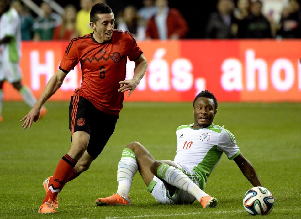 Mexico's Hector Herrera (8) charges for the ball around Nigeria's John Obi Mikel (10) during the first half of an international friendly soccer match Wednesday, March 5, 2014, in Atlanta. (AP Photo/David Tulis)